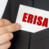 Business concept. Businessman holds a card with the text - ERISA